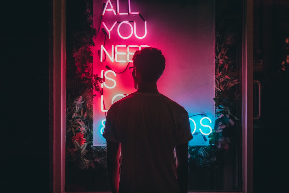 man standing in front of neon lights