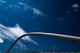 Wide-angle shot of a newly completed bridge featuring sleek arches against a deep blue sky.