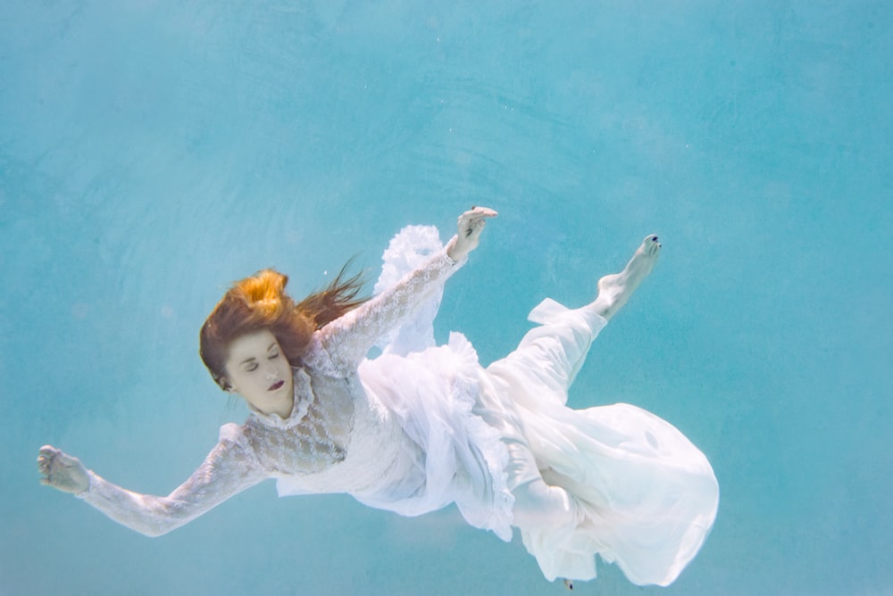 白いドレスを着た女性が泳いでいます