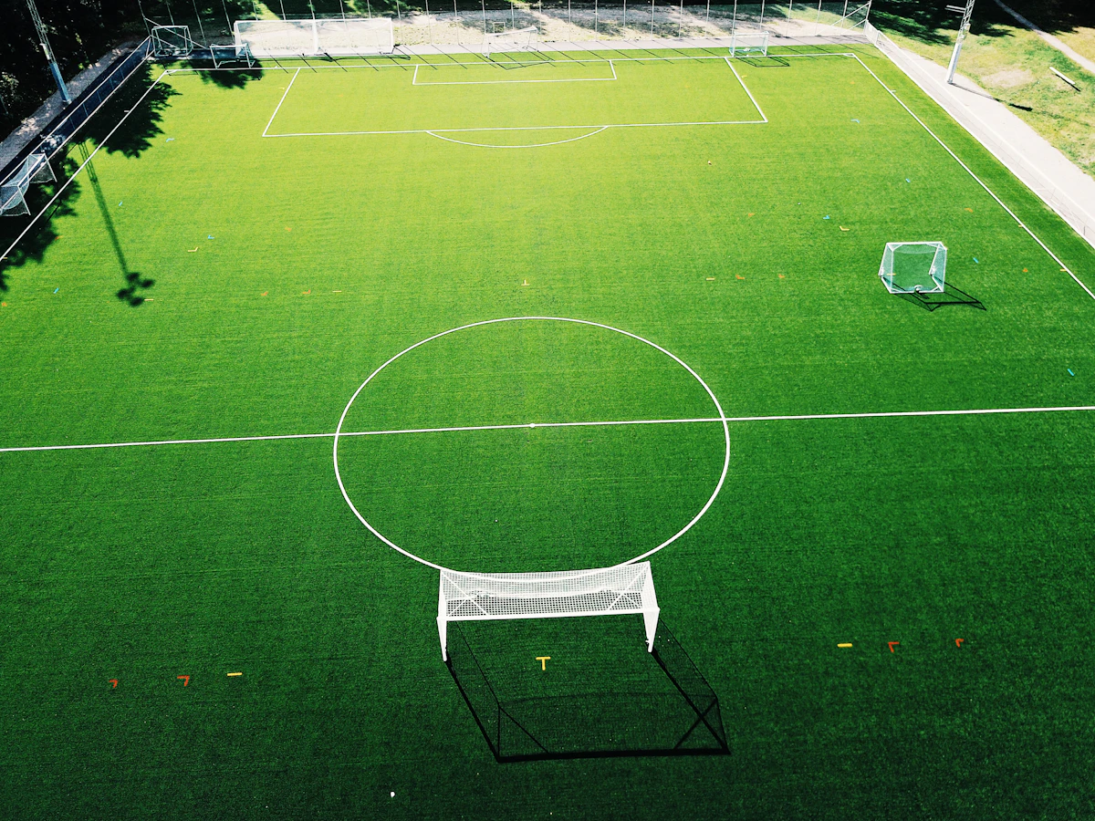 Championship blue hardcourt tennis court with net line markings and tournament balls
