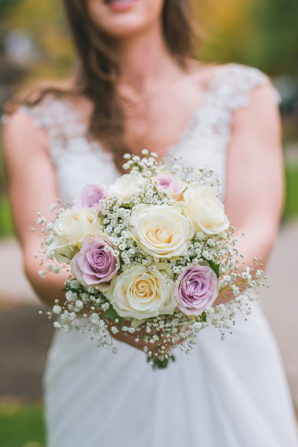 donna che tiene bianco e viola bouquet fotografia di messa a fuoco selettiva