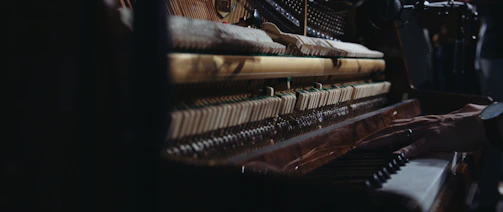Close-up of a piano technician adjusting piano strings inside a grand piano