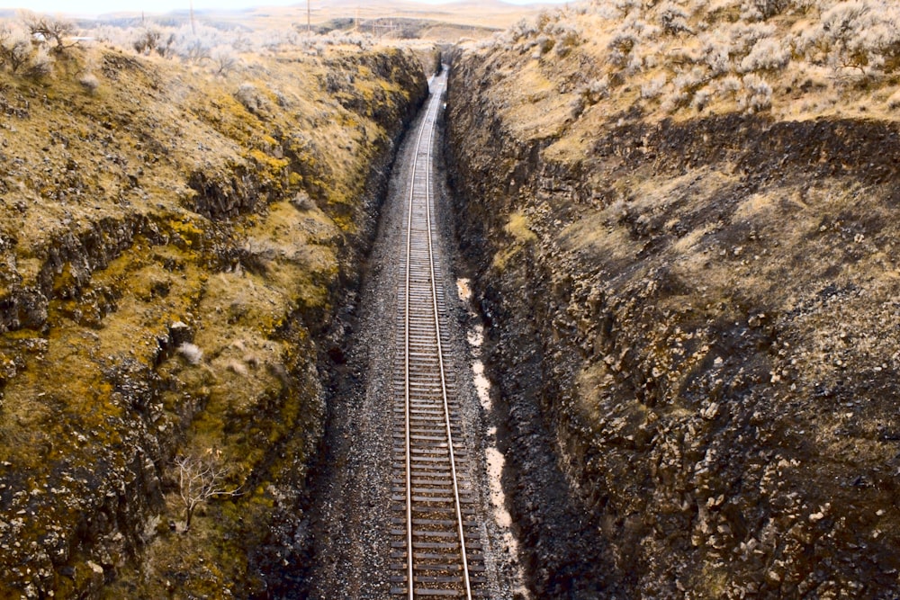 Ferrocarril entre colinas rocosas marrones