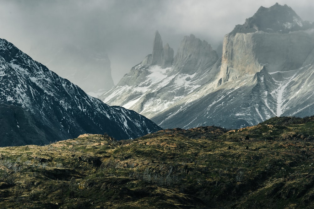 green hills near gray mountains