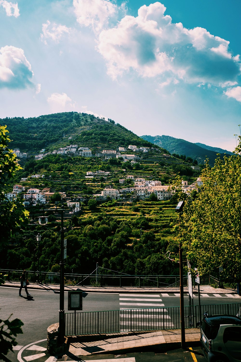 buildings on hill under clouds at daytime