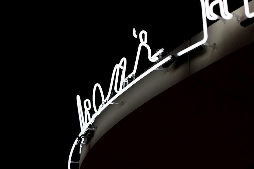 white neon signage on gray wall