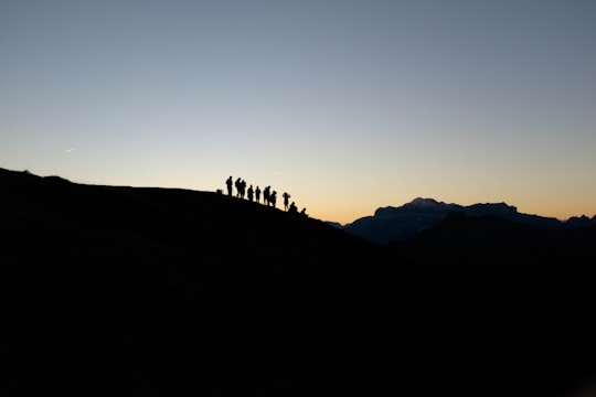 silhouette of people standing on mountain edge in Giau Pass Italy