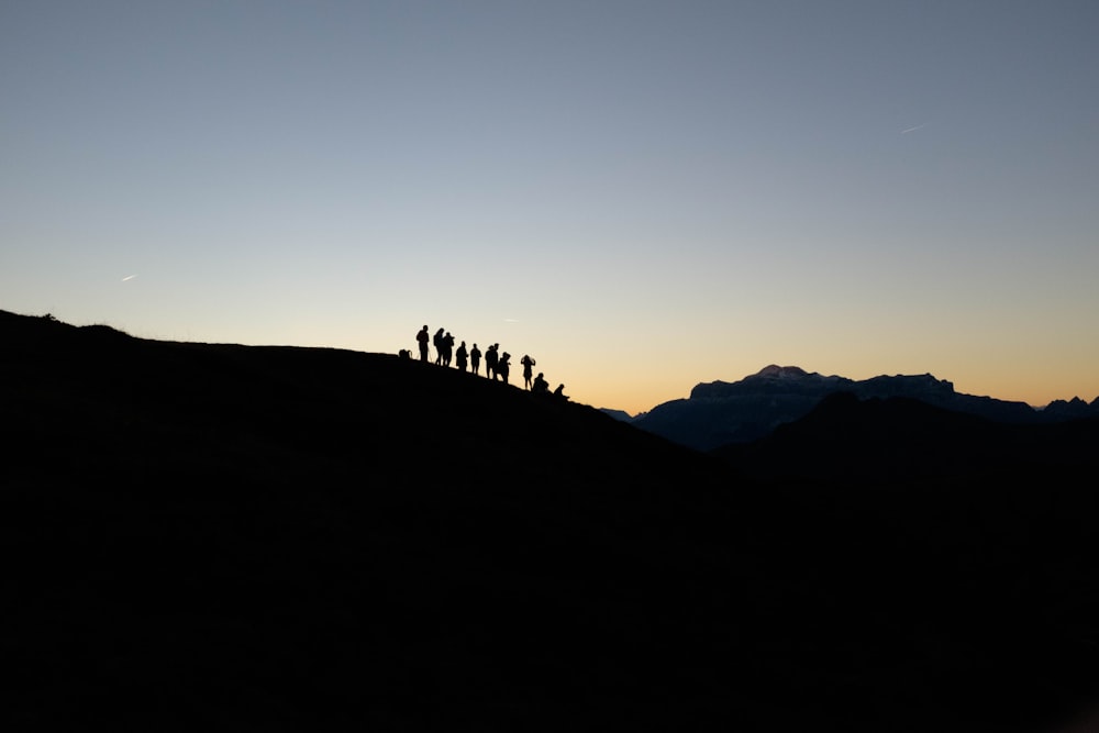 Silhouette von Menschen, die am Bergrand stehen