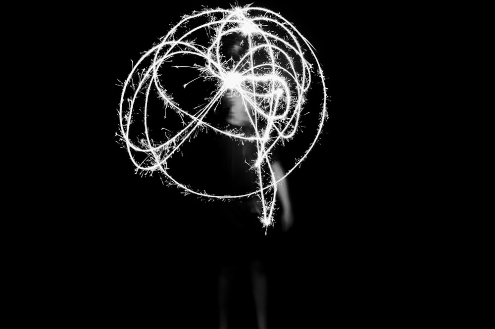 grayscale photography of person playing with light