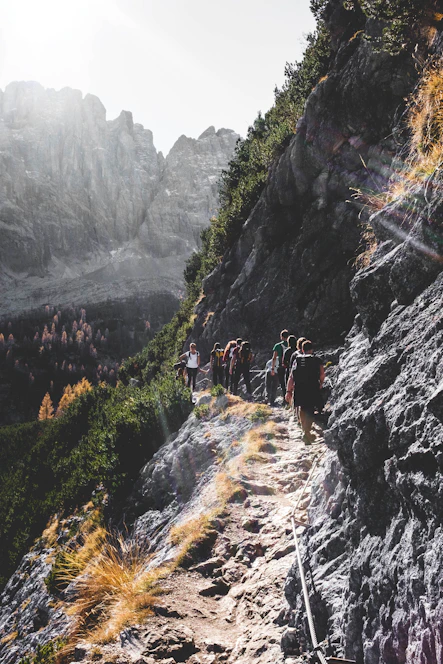 A group hiking along a sunlit trail in the Var Valley, with a backdrop of Mediterranean hills.