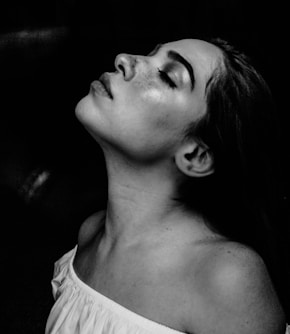 grayscale photo of a woman wearing white off-shoulder shirt