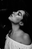 grayscale photo of a woman wearing white off-shoulder shirt