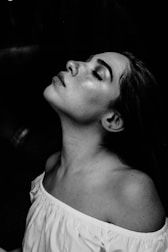 grayscale photo of a woman wearing white off-shoulder shirt