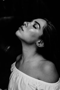 grayscale photo of a woman wearing white off-shoulder shirt