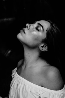 grayscale photo of a woman wearing white off-shoulder shirt