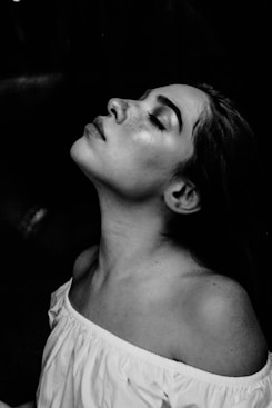 grayscale photo of a woman wearing white off-shoulder shirt