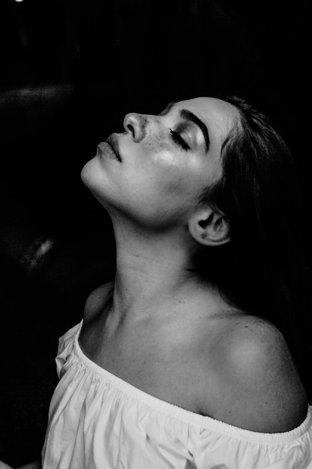 grayscale photo of a woman wearing white off-shoulder shirt