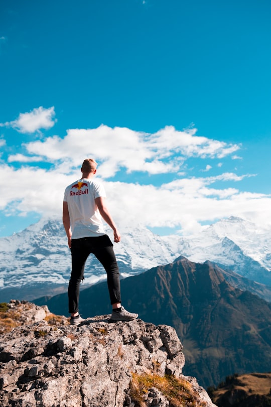 man standing at the edge of the cliff in Schynige Platte Switzerland