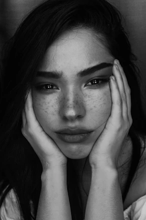 grayscale photography of woman with two hands on her face