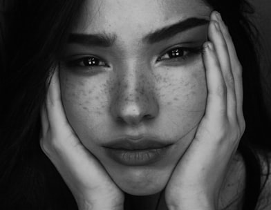 grayscale photography of woman with two hands on her face