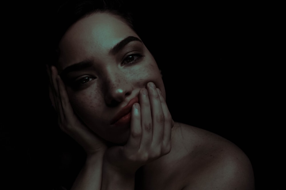 topless woman with head resting on palm