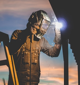 man on ladder welding post