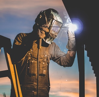 man on ladder welding post