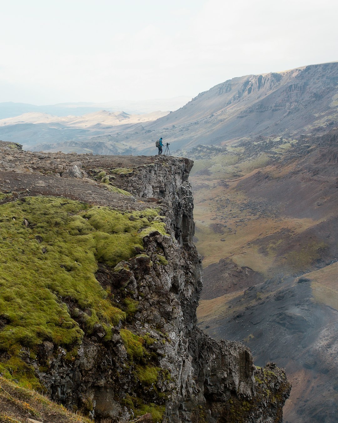 person standing beside cliff during daytime