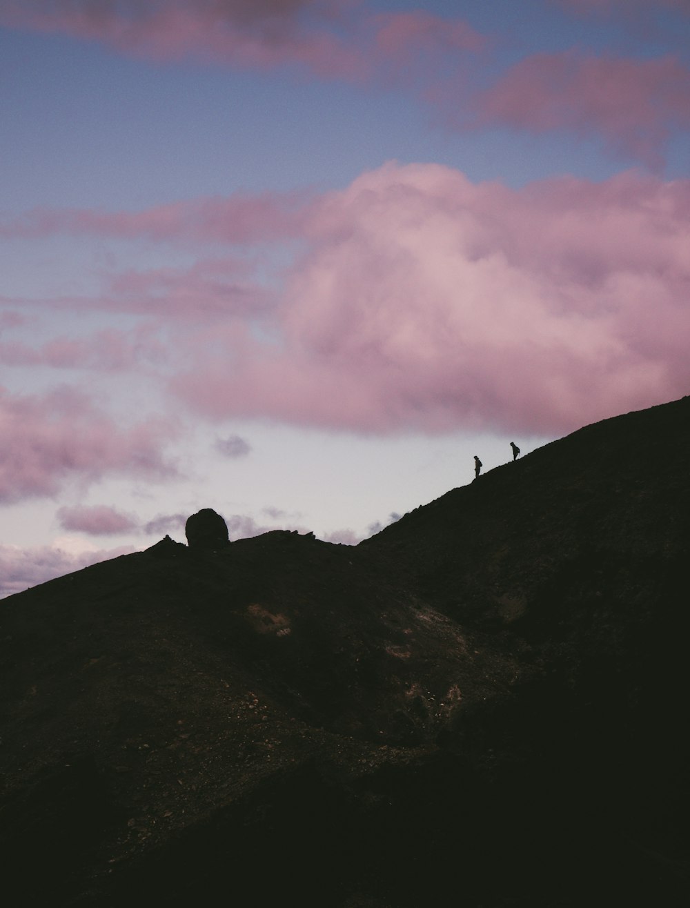 two silhouette of person walking down the hill