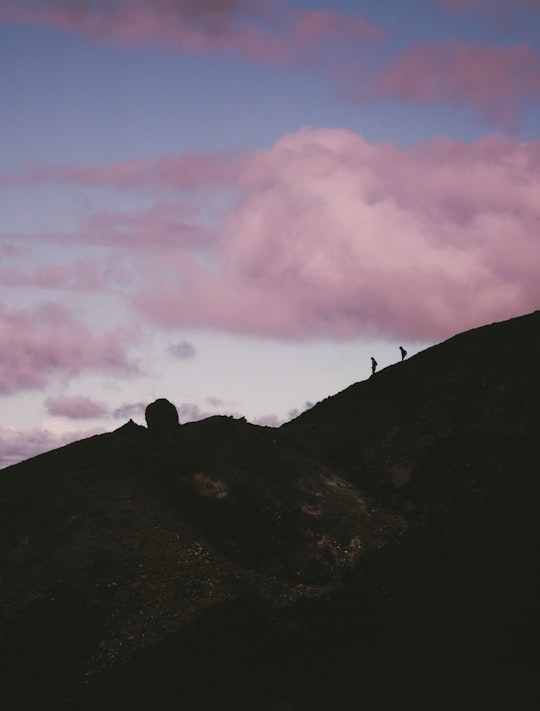 two silhouette of person walking down the hill in Tongariro National Park New Zealand