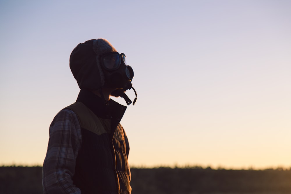 Homme debout sur un champ ouvert portant un respirateur