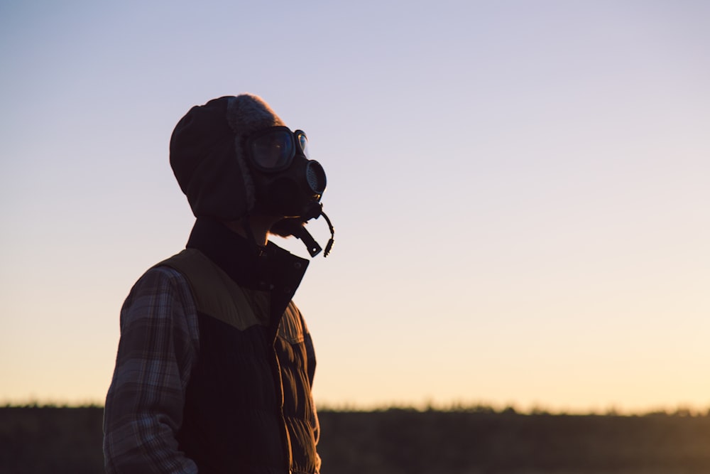 man standing on open field wearing respirator