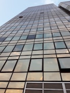 A towering glass skyscraper reflecting the city skyline at sunset.