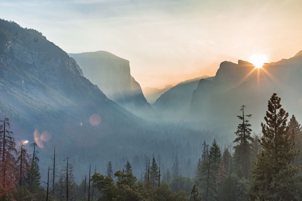 photographie de paysage du soleil jetant un coup d’œil sur la chaîne de montagnes