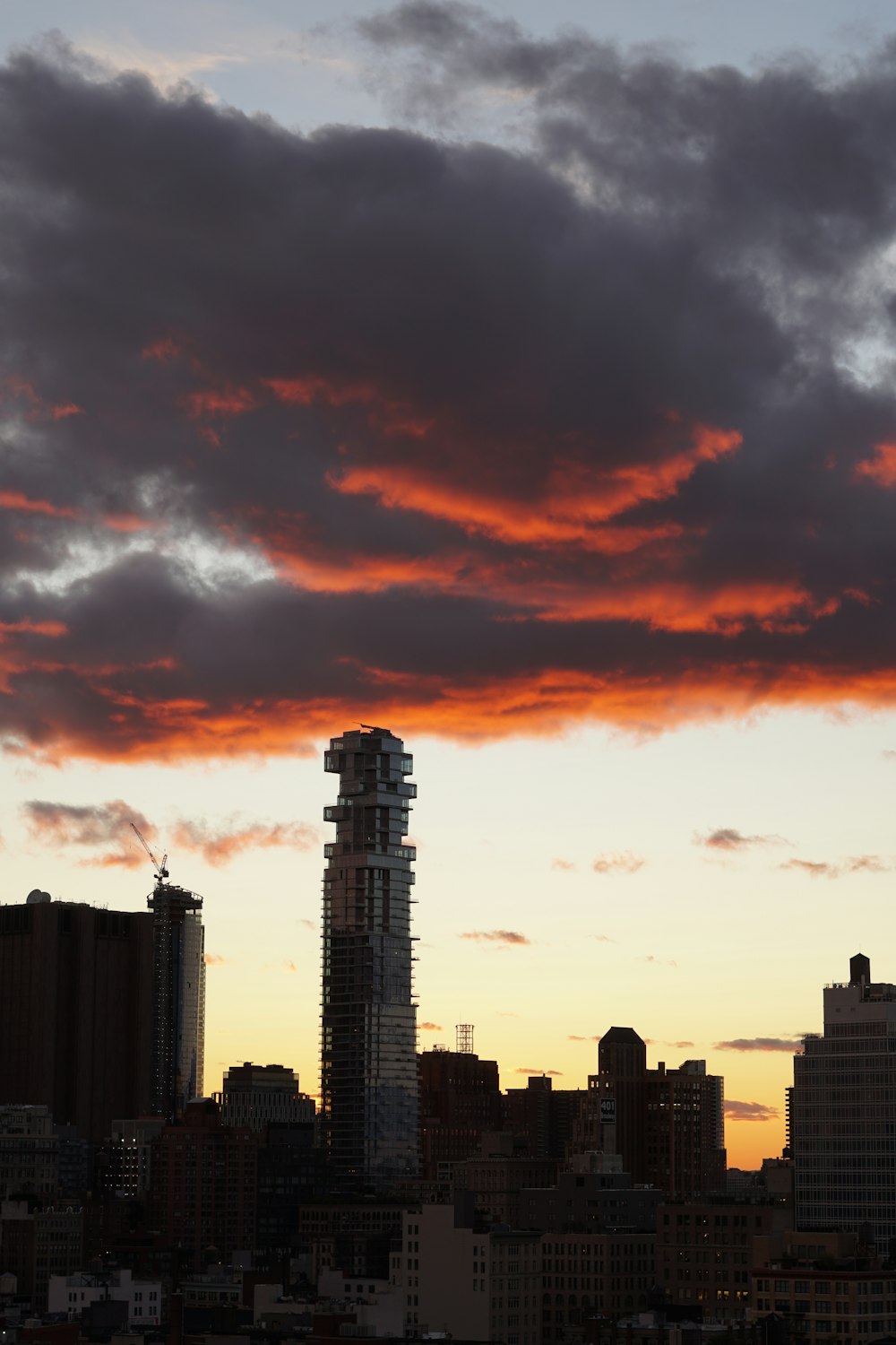 high rise building under red and gray gloomy sky