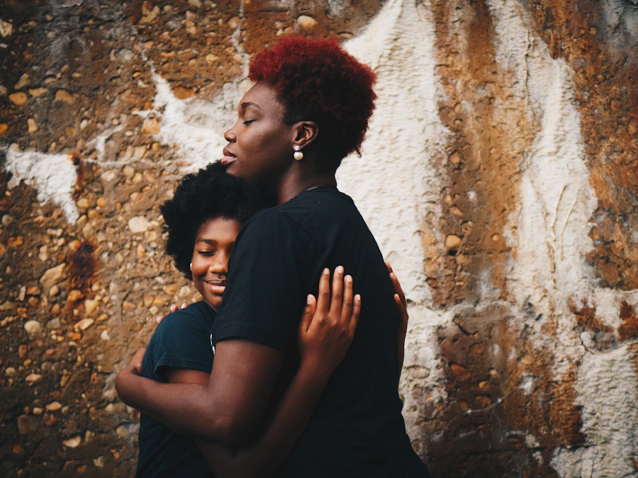 Two women holding each other in a warm hug, both smiling