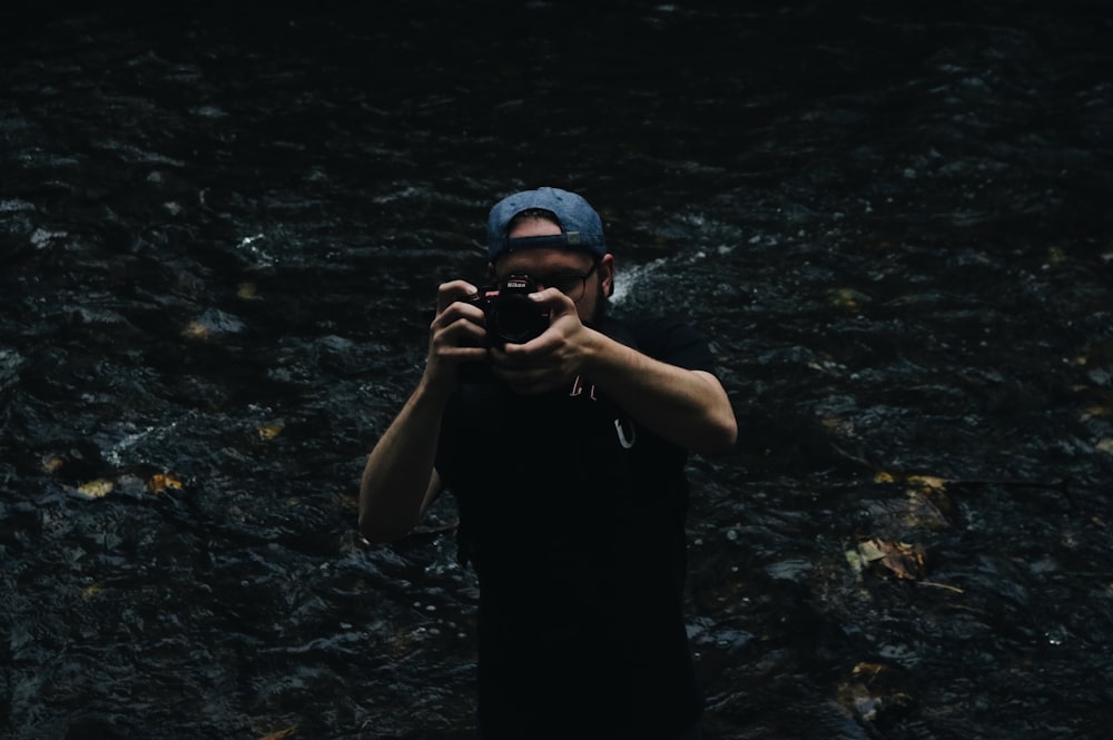 hombre tomando una foto con una cámara DSLR