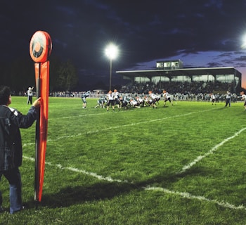 man holding football field post on side of field