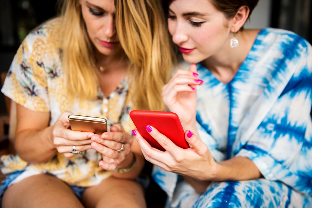 two women holding phones