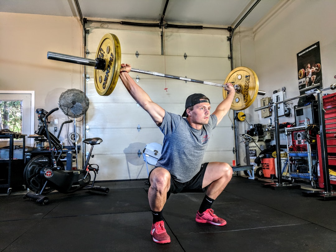 man lifting yellow barbell