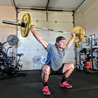 man lifting yellow barbell