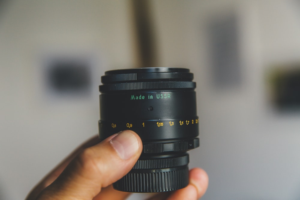 person holding black telephoto lens