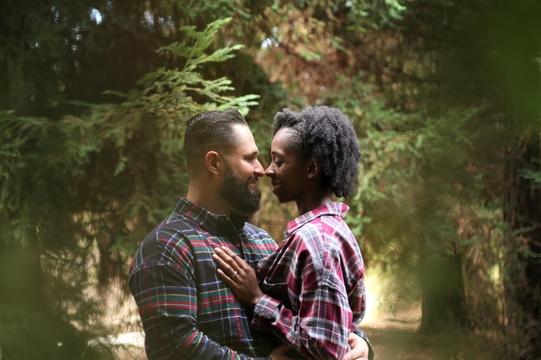 man and woman wearing button-up sports shirt on the center of trees,