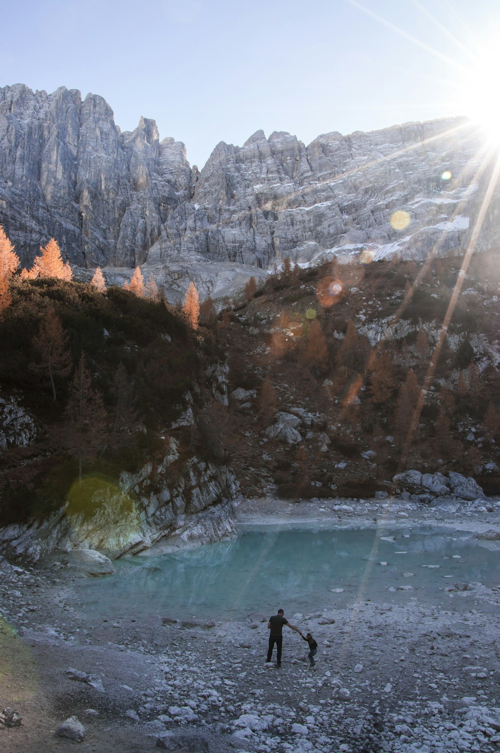 man and boy standing beside lake