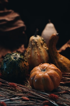 A cluster of polished, intricately carved gourds resting on a wooden table bathed in soft natural light.