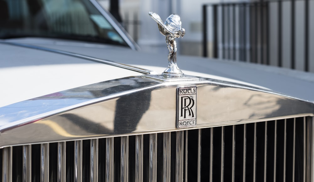 close up photography of silver Rolls-Royce emblem