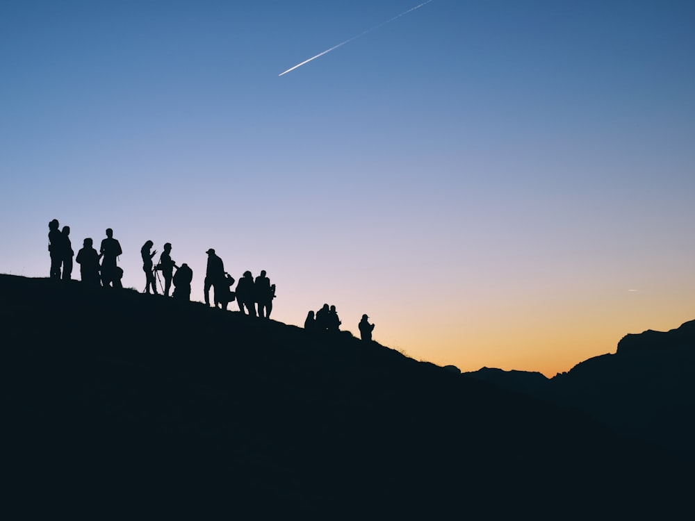 Silueta de la gente en la montaña bajo la caída de satr