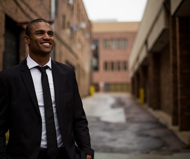 smiling man standing between brown concrete buildings at daytime