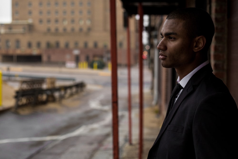 selective focus photography of man standing on sidewalk