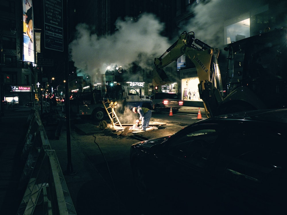 Trabajadores de la construcción y vehículos en la carretera durante la noche